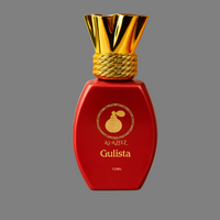 Red perfume bottle with gold cap on a pink background